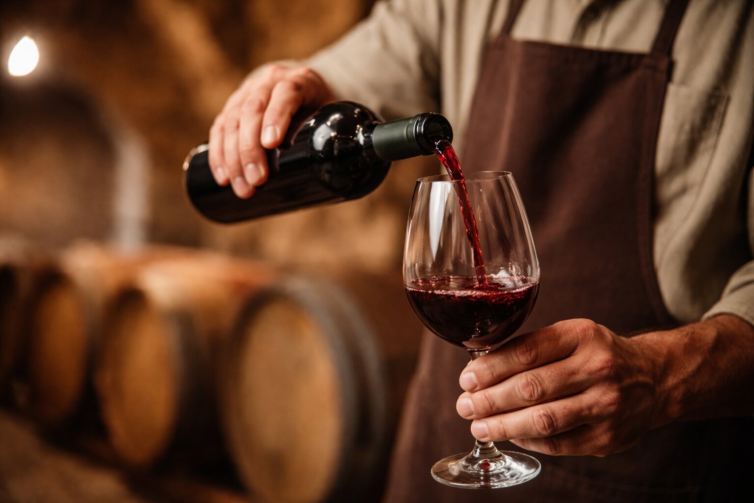 Winemaker pouring Chianti wine in a Tuscan cellar